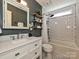 Stylish bathroom with subway tile shower, white vanity, black and white floors and decorative shelving at 4315 Poplar Grove Dr, Charlotte, NC 28269
