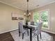 Formal dining room with a chandelier, gray upholstered chairs, and views to an adjacent window at 4315 Poplar Grove Dr, Charlotte, NC 28269