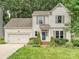 Traditional two-story home with manicured lawn, two-car garage, and charming architectural details at 4315 Poplar Grove Dr, Charlotte, NC 28269