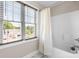 Bathroom features a shower/tub combination, shower curtain, and large windows with outside view at 4941 Southview Dr, Hickory, NC 28602