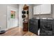 Well-equipped laundry room with wooden floors, modern appliances, and a decorative mirror at 4941 Southview Dr, Hickory, NC 28602
