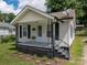Inviting one-story home with a covered porch, black accents and lovely front garden at 520 E Maple Ave, Gastonia, NC 28054