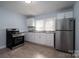 Well-lit kitchen boasting stainless appliances, white cabinets, and stylish laminate floors at 520 E Maple Ave, Gastonia, NC 28054