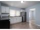 Bright kitchen featuring white cabinets, stainless steel appliances, and vinyl flooring at 520 E Maple Ave, Gastonia, NC 28054