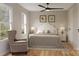 Cozy bedroom featuring hardwood floors, a ceiling fan, and a comfortable sitting area at 528 Beatties Ford Rd, Charlotte, NC 28216