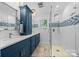 Modern bathroom with double vanity, blue cabinets, and walk-in shower with glass door at 570 Blue Heron Rd, Salisbury, NC 28146
