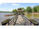 Long wooden dock with covered seating area, boat slip, and beautiful lake views at 570 Blue Heron Rd, Salisbury, NC 28146
