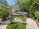 Picturesque lakefront home featuring mature landscaping, a circular driveway, and a stone facade at 570 Blue Heron Rd, Salisbury, NC 28146