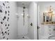 Modern shower with pebble floor, white tiles, river rock accent, and gold hardware at 570 Blue Heron Rd, Salisbury, NC 28146