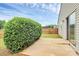 Lush backyard with concrete patio, fence and bush at 5804 Fairchase Ave, Charlotte, NC 28269