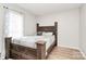 Cozy bedroom featuring hardwood floors, a natural light window, and a wooden bed frame at 5804 Fairchase Ave, Charlotte, NC 28269