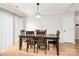 The dining room has wooden table with six chairs and a modern light fixture above at 5804 Fairchase Ave, Charlotte, NC 28269