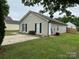 Neutral single-story home with vinyl siding and a concrete driveway lined with manicured landscaping at 5804 Fairchase Ave, Charlotte, NC 28269
