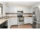 Modern kitchen with stainless steel appliances, white cabinets, and stylish backsplash at 5804 Fairchase Ave, Charlotte, NC 28269