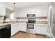Updated kitchen with stainless steel appliances, white cabinets, and a modern microwave at 5804 Fairchase Ave, Charlotte, NC 28269