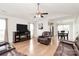 Bright living room featuring hardwood floors, a ceiling fan, and a cozy fireplace with TV at 5804 Fairchase Ave, Charlotte, NC 28269