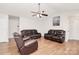 Open living room with vaulted ceilings, hardwood flooring, and comfortable leather sofas at 5804 Fairchase Ave, Charlotte, NC 28269