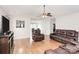 Spacious living room with hardwood floors, modern ceiling fan, and comfortable leather seating at 5804 Fairchase Ave, Charlotte, NC 28269
