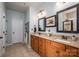 Bathroom featuring double sinks, granite countertops, tile flooring, and decorative mirrors at 5849 Mcclintock Dr # 117, Denver, NC 28037