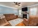 Cozy living room with a fireplace, ceiling fan, and comfortable seating at 5849 Mcclintock Dr # 117, Denver, NC 28037