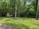 Expansive backyard with mature trees and a storage shed, providing ample space for outdoor activities at 703 S Highway 27 Hwy, Stanley, NC 28164