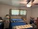 Bedroom with a blue-covered bed, neutral-toned walls, and a ceiling fan for added comfort at 703 S Highway 27 Hwy, Stanley, NC 28164