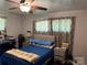Bedroom with a blue-covered bed, neutral-toned walls, and a ceiling fan for added comfort at 703 S Highway 27 Hwy, Stanley, NC 28164