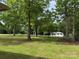 Spacious front yard with mature trees and well-maintained lawn showcasing the charming home at 703 S Highway 27 Hwy, Stanley, NC 28164
