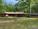 Ranch-style home with brick exterior, green shutters, and a well-maintained lawn and mature trees surrounding the property at 703 S Highway 27 Hwy, Stanley, NC 28164