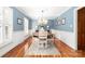 This traditional dining room features a round table, wood floors, a decorative rug, and blue paneled walls at 707 Saint Cloud Dr, Statesville, NC 28625