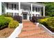Elegant white home with brick stairs, black shutters, and manicured landscaping at 707 Saint Cloud Dr, Statesville, NC 28625