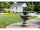 Ornate multi-tiered fountain surrounded by lush landscaping, creating a tranquil focal point in the yard at 707 Saint Cloud Dr, Statesville, NC 28625