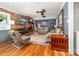 Cozy living room features a brick fireplace, wood paneled walls, and hardwood floors at 707 Saint Cloud Dr, Statesville, NC 28625