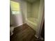 Cozy bathroom with a garden tub, wood-look floors, and a neutral color palette at 716 Coy Ct, Charlotte, NC 28216