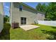 A fenced backyard featuring a concrete patio, green lawn, and the exterior of a home with siding at 7311 Fig Ln, Charlotte, NC 28215