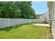 Green backyard, with a partial view of a white fence and trees, offering a private outdoor space at 7311 Fig Ln, Charlotte, NC 28215
