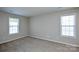 This bedroom features neutral walls, two windows providing ample natural light, and plush carpeting at 7311 Fig Ln, Charlotte, NC 28215
