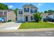 Charming two-story home featuring a well-manicured lawn, attached garage, and traditional design with black shutters at 7311 Fig Ln, Charlotte, NC 28215