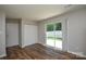 Bright living room featuring wood floors, closet, and sliding glass door to outdoor space at 7311 Fig Ln, Charlotte, NC 28215