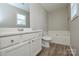Well-lit bathroom with vanity, toilet, bathtub, and vinyl flooring at 7711 Brisbane Ct, Charlotte, NC 28215