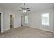 Spacious bedroom features a ceiling fan, neutral walls, and carpeted floors at 7711 Brisbane Ct, Charlotte, NC 28215
