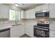 Bright kitchen featuring white cabinets, ample countertops, and stainless steel appliances at 7711 Brisbane Ct, Charlotte, NC 28215