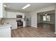 Well-lit kitchen featuring stainless steel appliances, white cabinets and a seamless flow to living area at 7711 Brisbane Ct, Charlotte, NC 28215