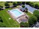 Aerial view of a fenced community pool, playground, and ample green space at 786 Sw Treva Anne Sw Dr, Concord, NC 28027