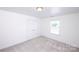 This is a bedroom with light-colored carpet, white walls and trim, a window, and a standard double door closet at 786 Treva Anne Sw Dr, Concord, NC 28027