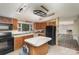 Cozy kitchen with wood cabinets, a central island, and black appliances, ready for your culinary touch at 811 Acclaim Dr, York, SC 29745