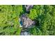 Aerial view of an estate enveloped by mature trees, featuring a pool and expansive outdoor living at 8534 Highgrove St, Charlotte, NC 28277