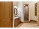 A stylish bathroom with tiled floors, a wooden vanity, and a glass door shower at 8534 Highgrove St, Charlotte, NC 28277