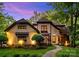 Charming two-story home with landscaped yard and stone walkway, illuminated by exterior lighting at dusk at 8534 Highgrove St, Charlotte, NC 28277