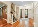 Spacious foyer boasting hardwood floors, staircase, paneled walls, and stylish entry with double doors at 8534 Highgrove St, Charlotte, NC 28277